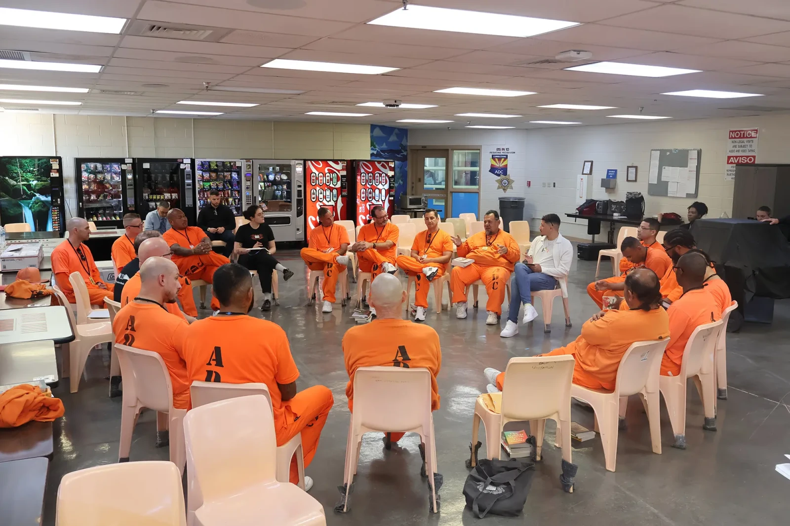 Book discussion inside Arizona State Prison Complex - Eyman. Men clad in orange seated in a circle discussing books inside Arizona State Prison Complex - Eyman.