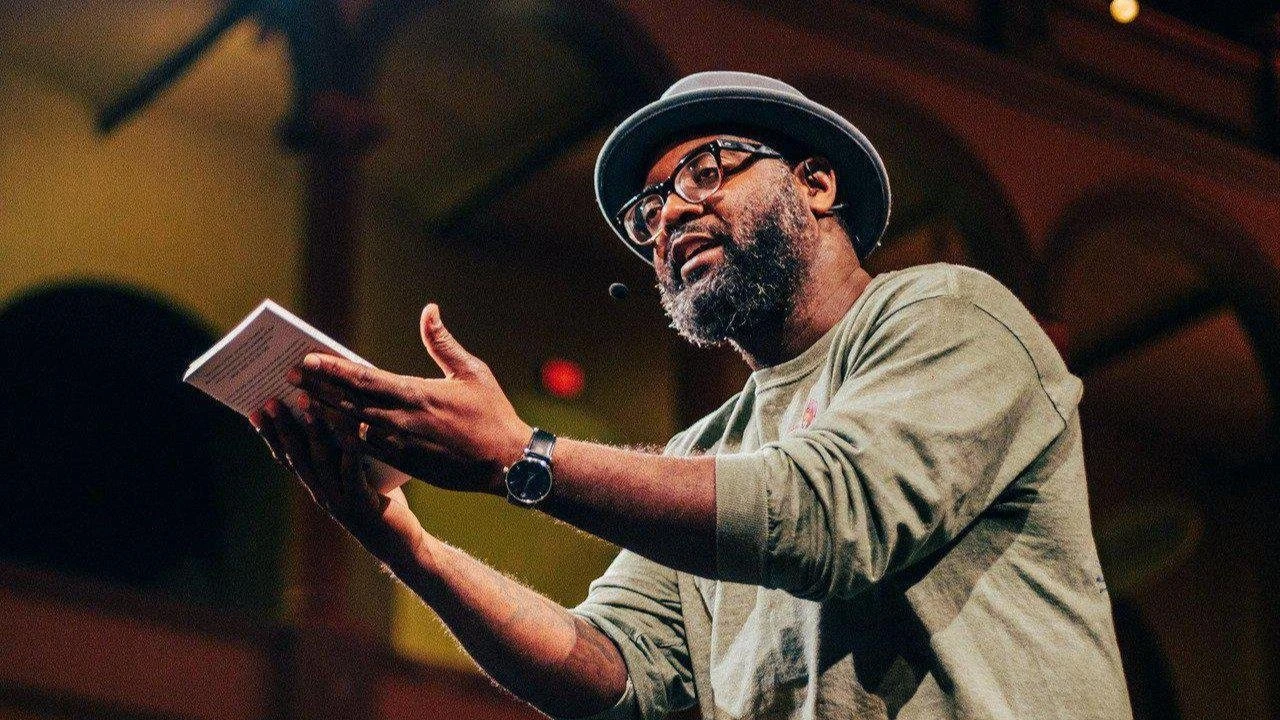 With the wild belief that a book might provide solace and wings. Freedom Reads Founder & CEO Reginald Dwayne Betts holds a book during his performance.