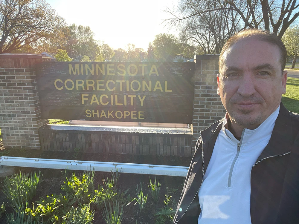 Freedom Reads Communications Manager Steven Parkhurst outside of Minnesota Correctional Facility - Shakopee. Freedom Reads Communications Manager Steven Parkhurst takes a selfie with the sign outside of Minnesota Correctional Facility - Shakopee.
