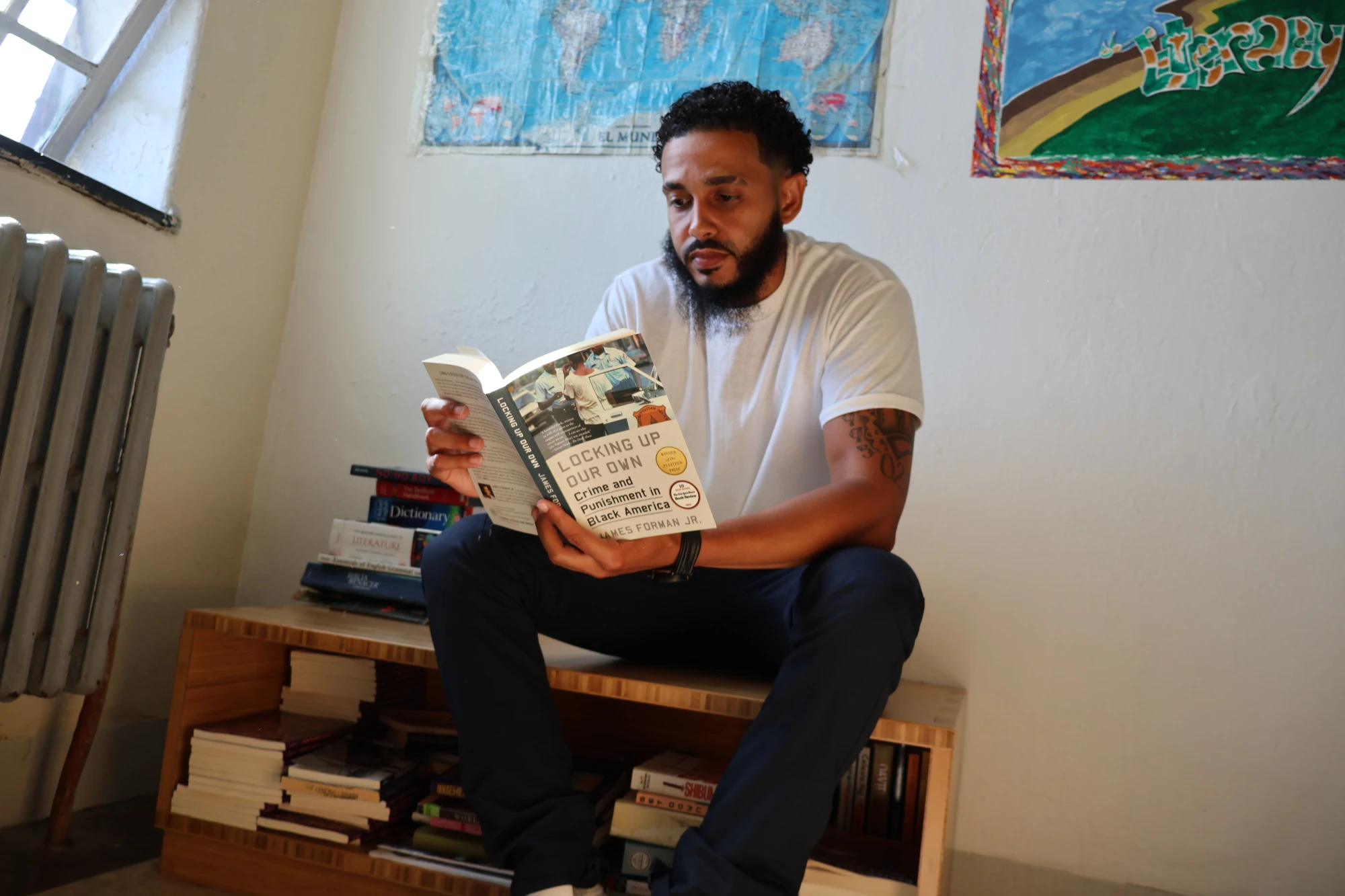 Freedom Library Patron Hector reading at MCI-Norfolk. Freedom Library Patron Hector sits on a Freedom Library bench reading a book.