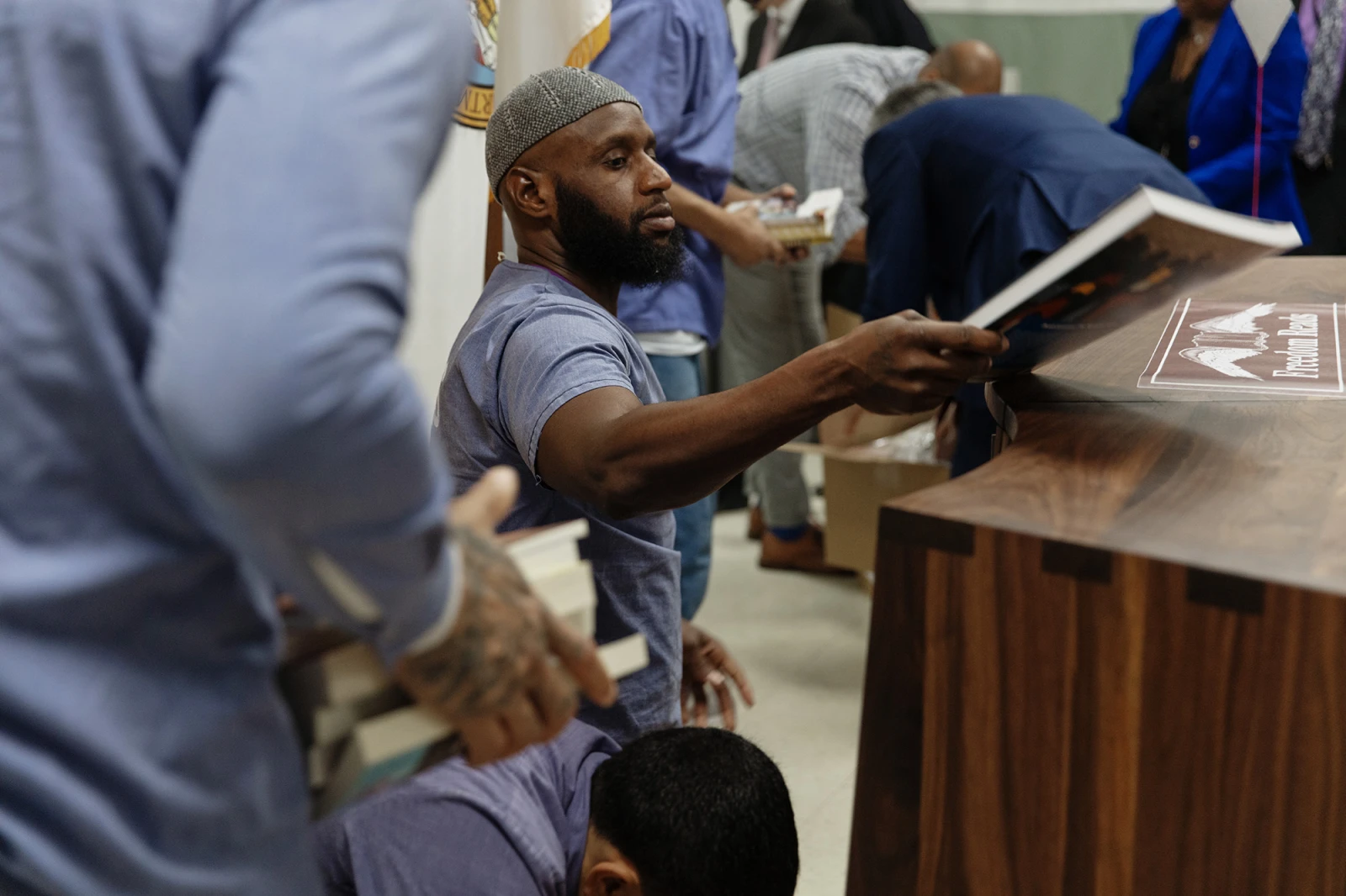 Freedom Library opening at Dorsey Run Correctional Facility in Maryland. Library Patrons carry stacks of books over to one of the brand new Freedom Libraries at Dorsey Run Correctional Facility in Maryland during an opening.