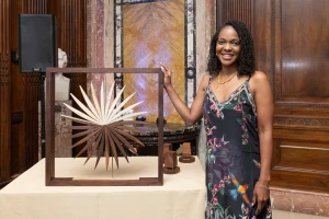 On August 1, 2024, Imani Perry, author of *South to America: A Journey Below the Mason-Dixon to Understand the Soul of a Nation*, was awarded the inaugural Inside Literary Prize. Imani Perry stands, smiling with the Inside Literary Prize award.