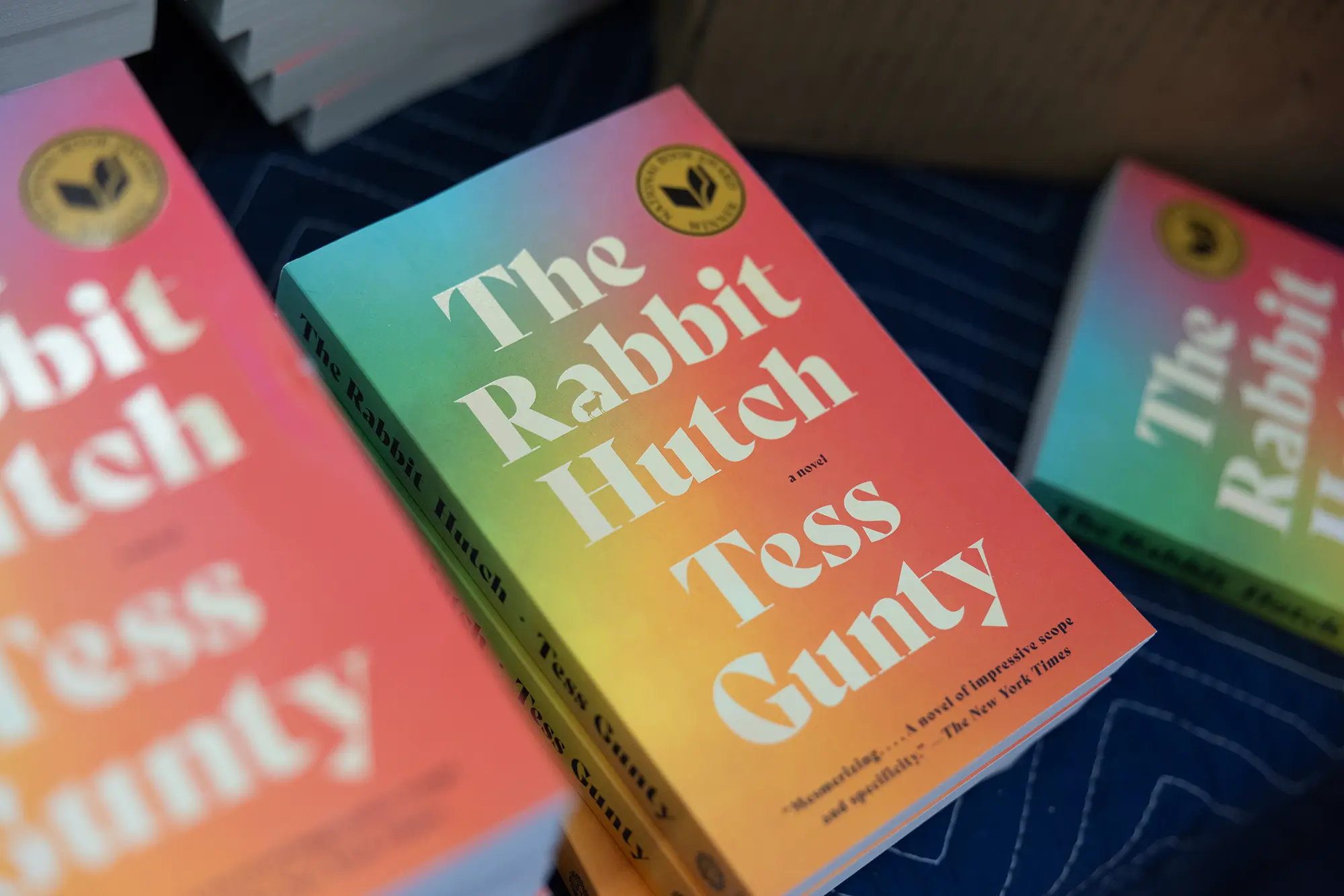 A closeup photo of the soft rainbow-colored book cover for The Rabbit Hutch by Tess Gunty